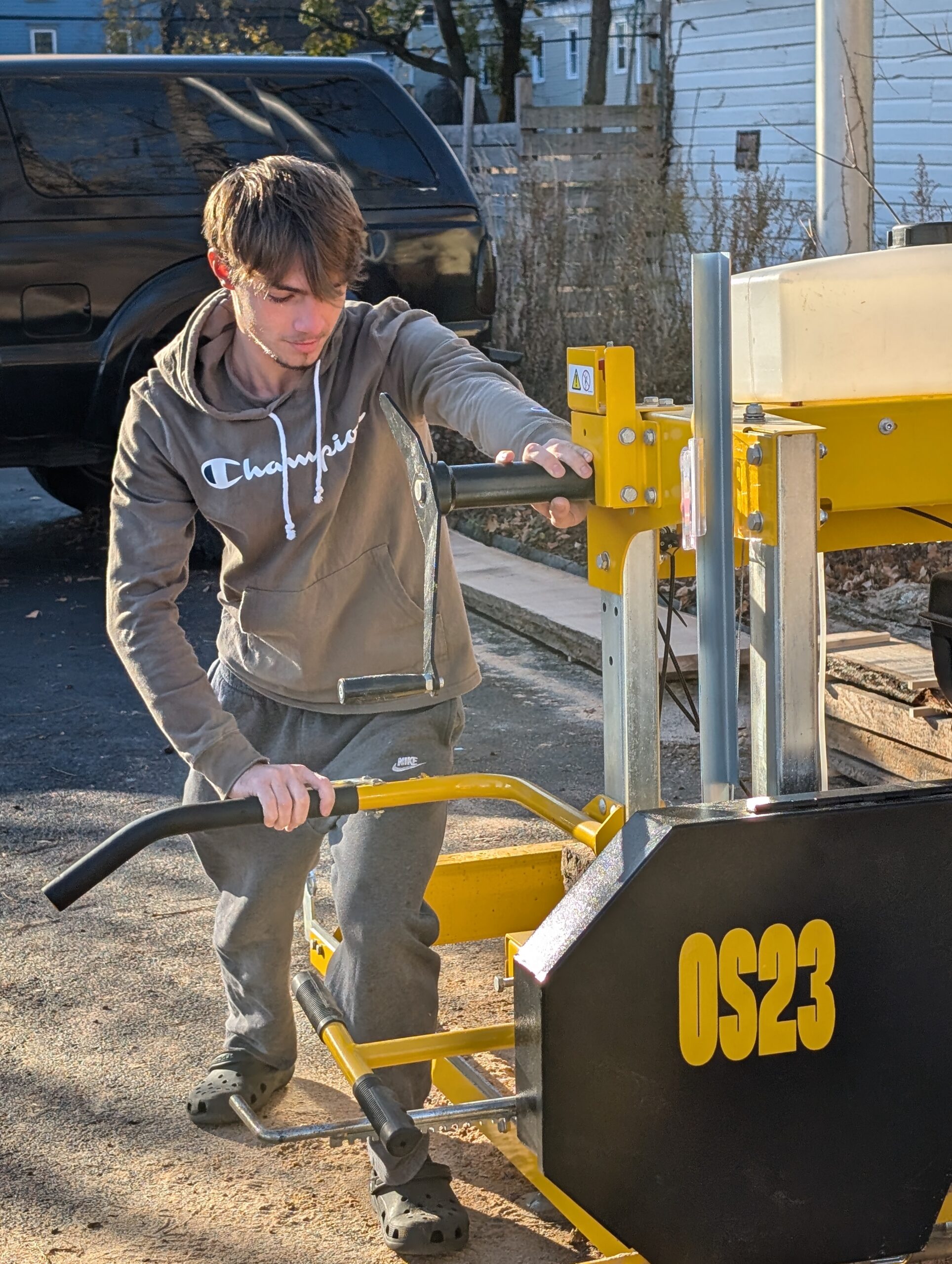 Student using sawmill to cut log,