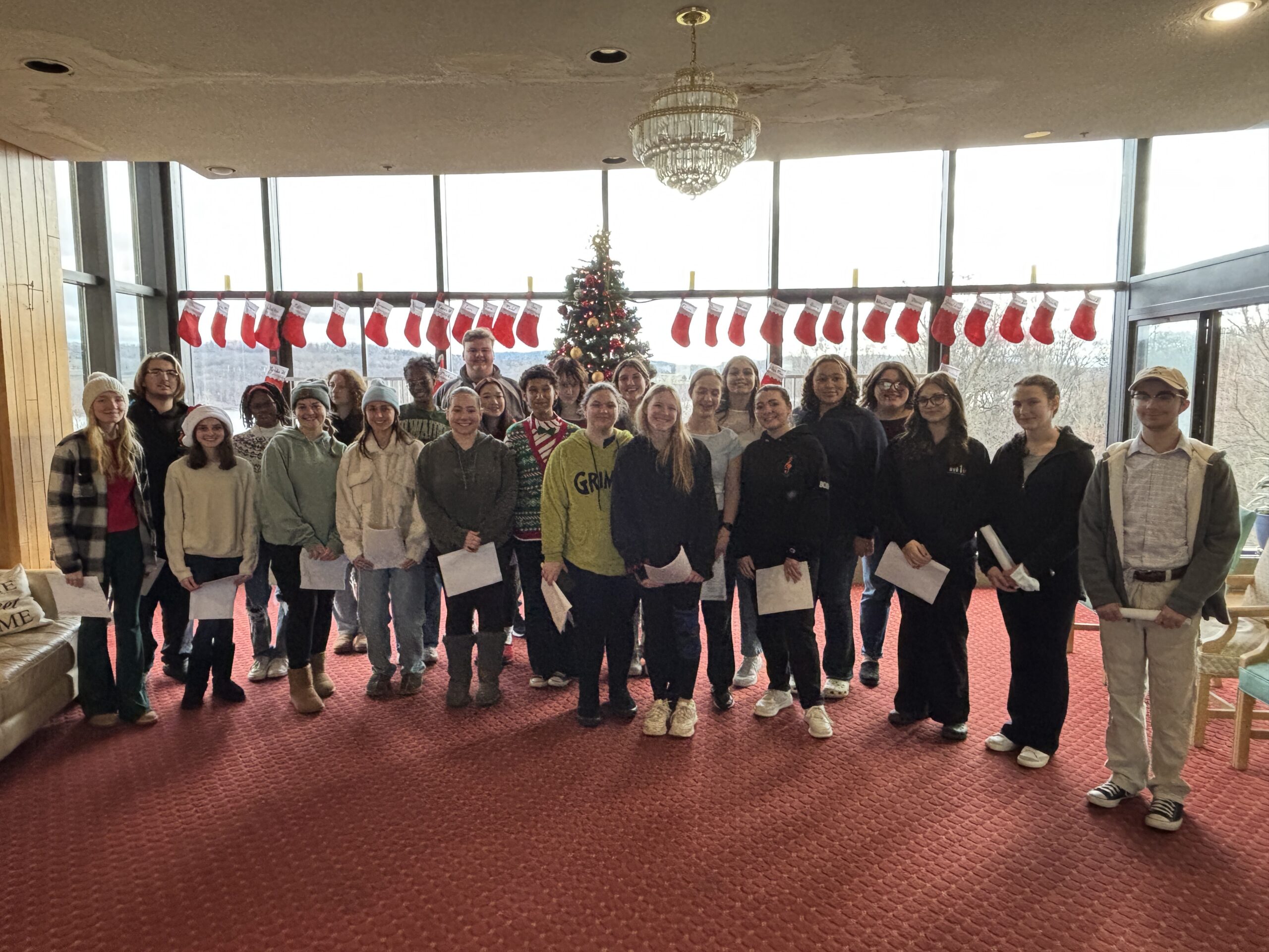 student pose for group photo in large room