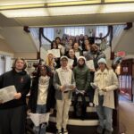 students singing on staircase