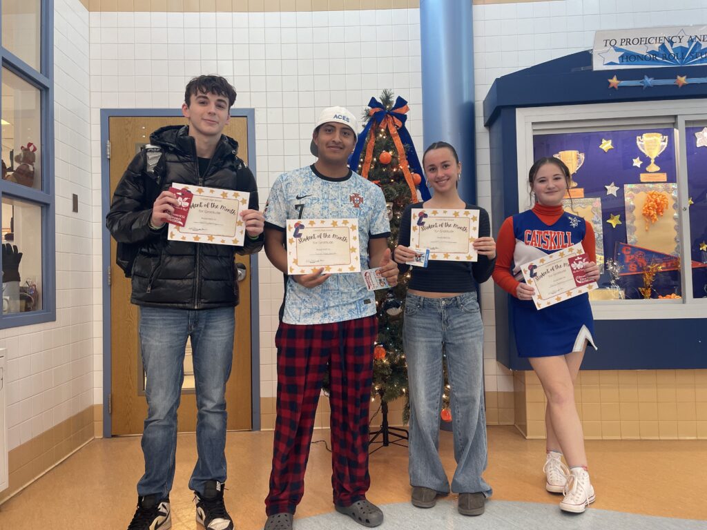 four teenage students holding certificates and smiling