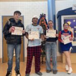 four teenage students holding certificates and smiling