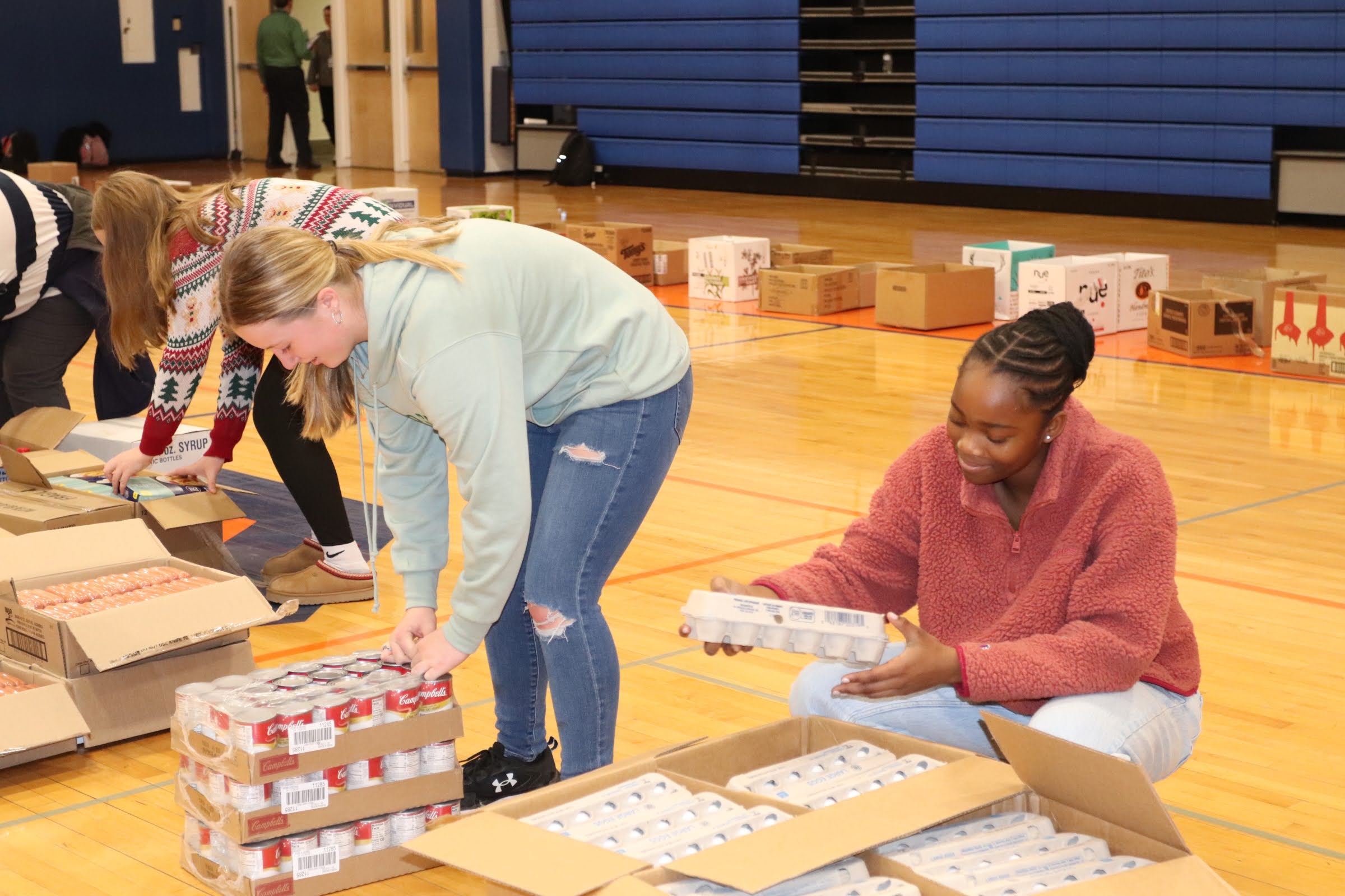 three girls packing boxes of food
