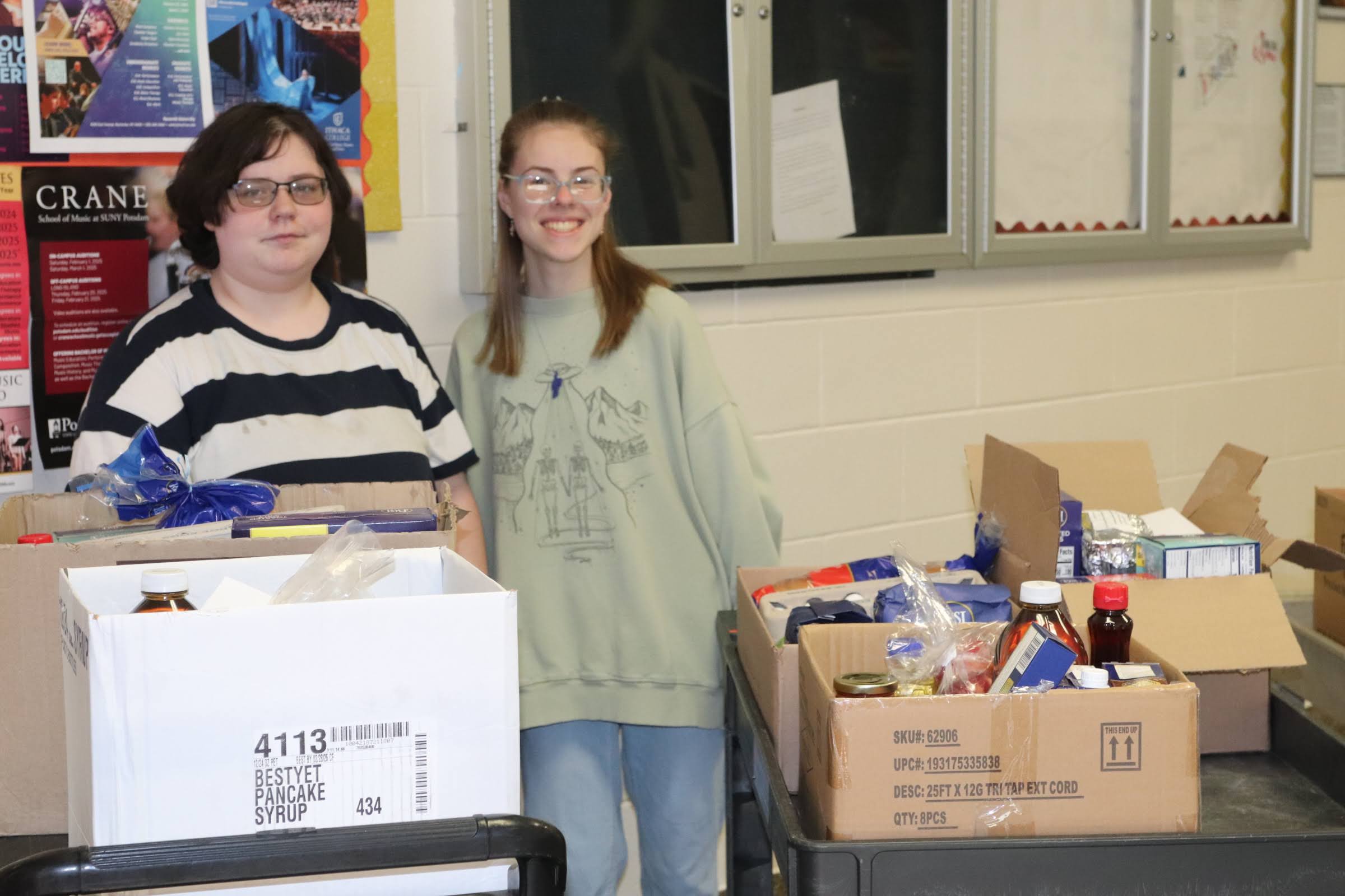 girls standing with boxes of food