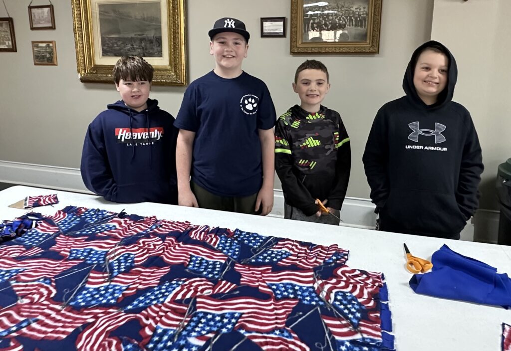four boys pose with blanket