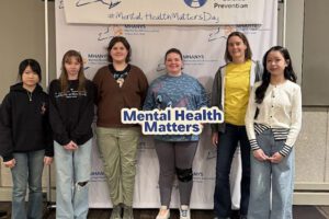 students pose with mental health matters sign