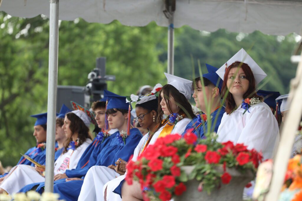 graduates seated under tent