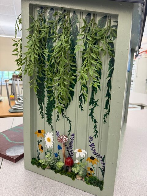vines and ferns hanging from wooden box
