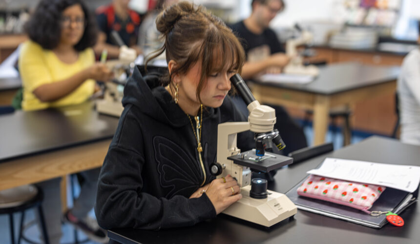 student looking through microscope