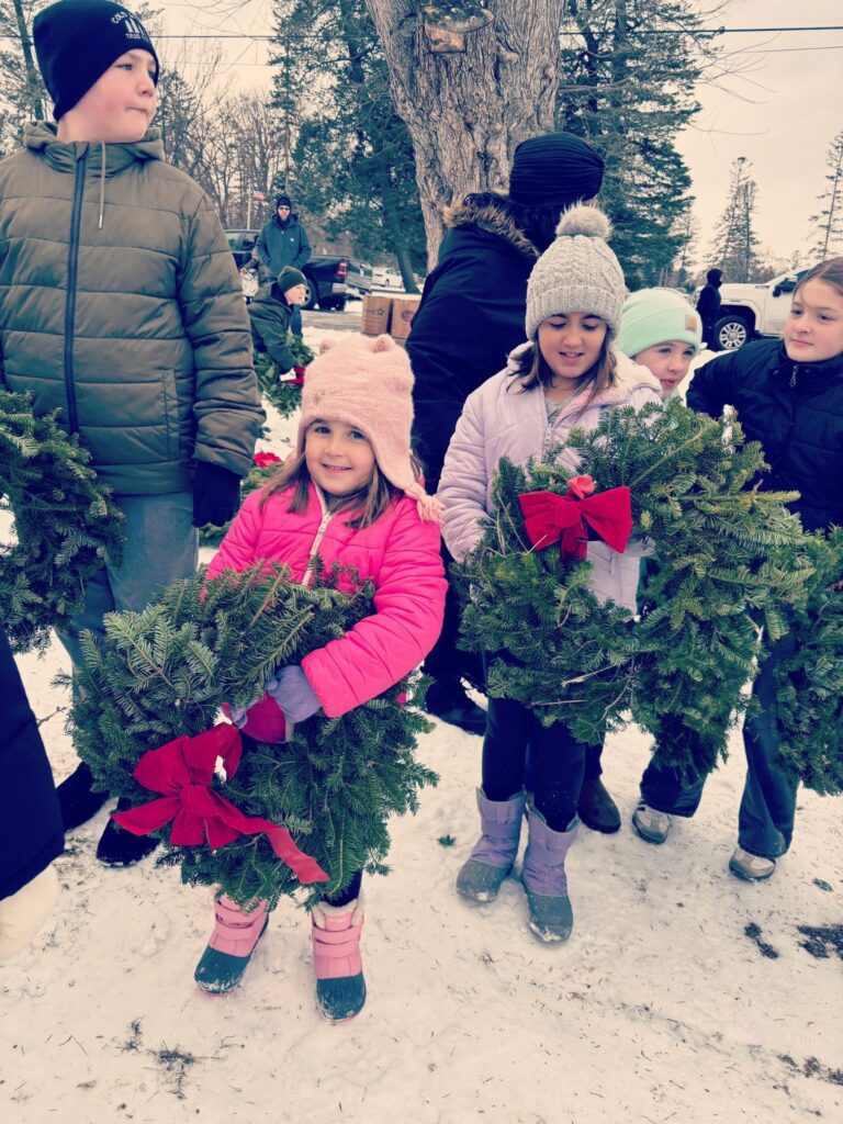 students laying wreaths on veterans' graves