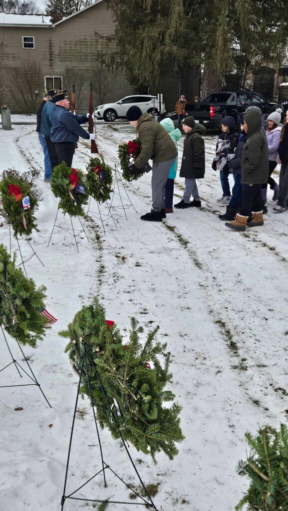 students laying wreaths on veterans' graves