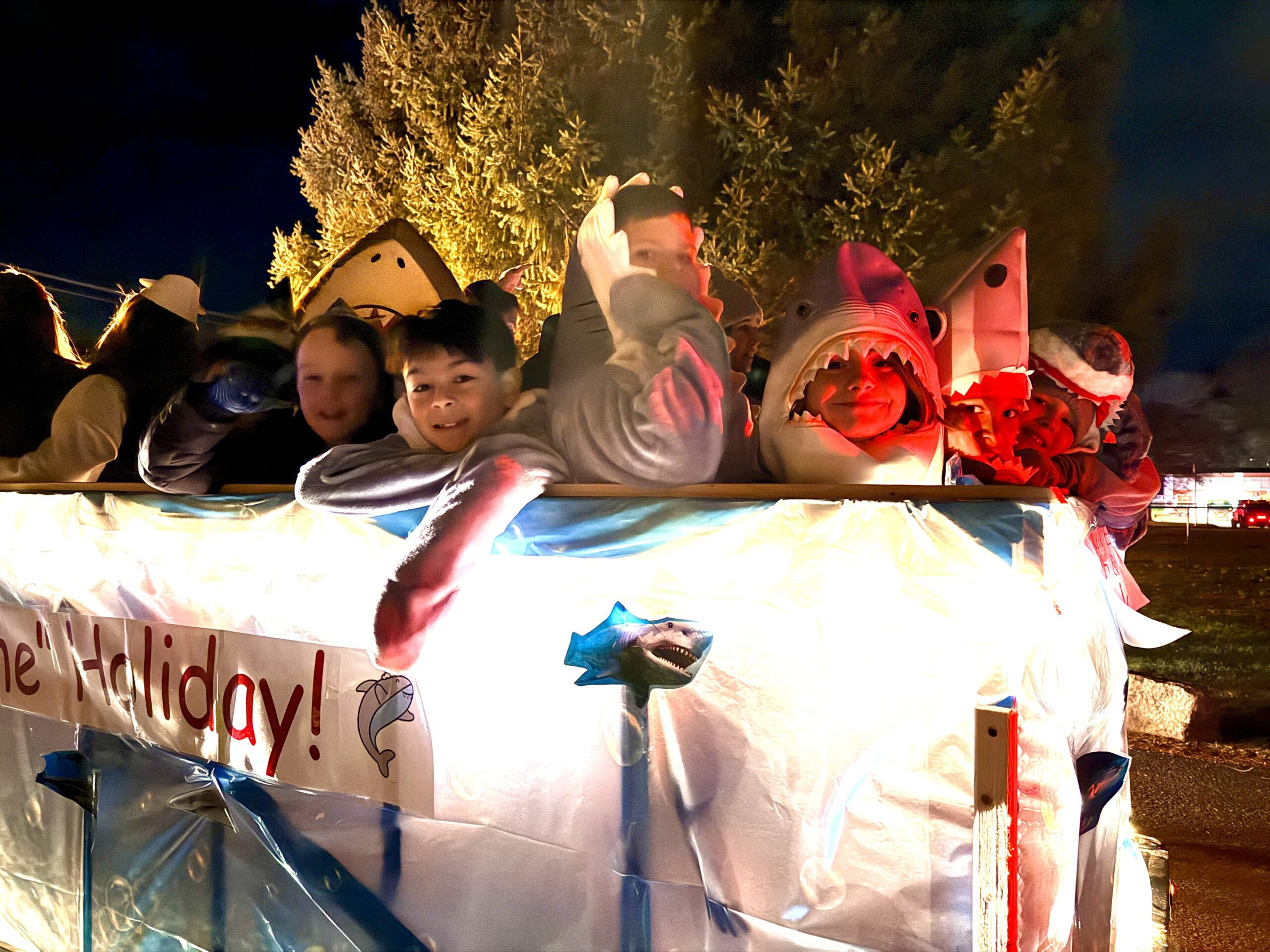 parade float with students dressed as sharks on it