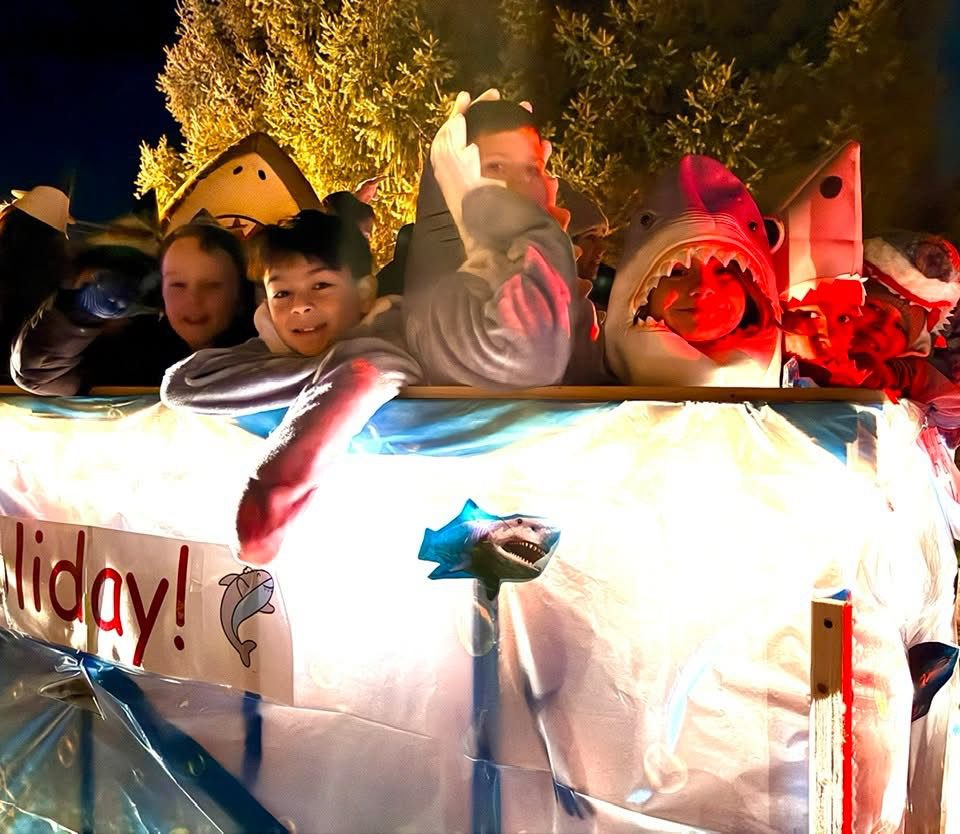 parade float with students dressed as sharks on it