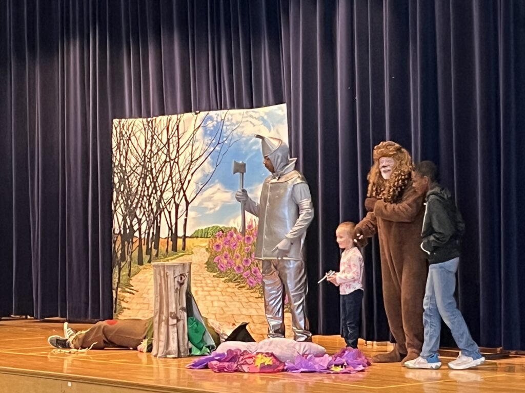 student on stage with cast of The Wizard of Oz