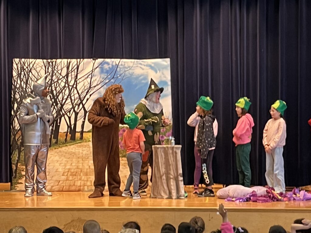 students acting out scene with cast of The Wizard of Oz