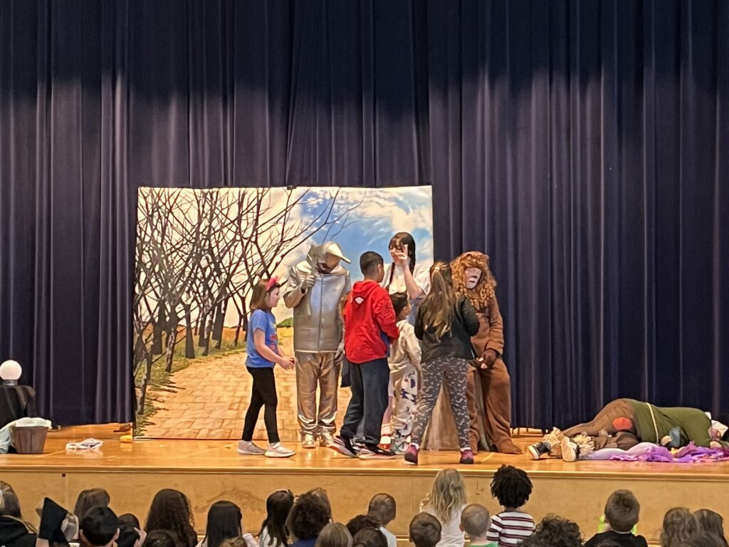 students on stage with cast of The Wizard of Oz