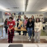 high school students pose with cat