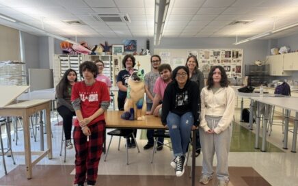 high school students pose with cat