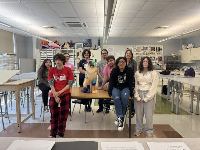 high school students pose with cat
