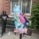 Cat statue with trees and flowers painted on it