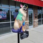 cat statue painted with color blotches in front of medical building