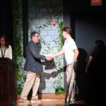man shaking boy's hand