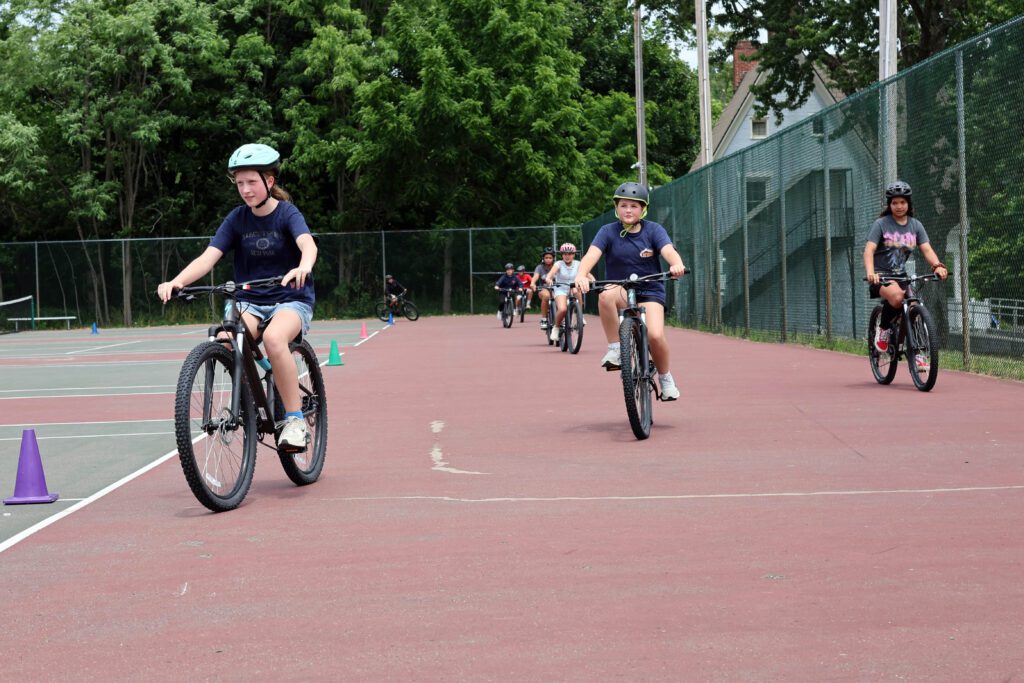 girls riding mountain bikes on tennis court