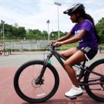 girl riding mountain bikes on tennis court