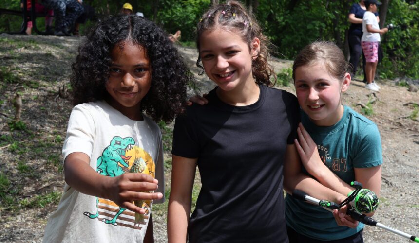 three girls pose with fish