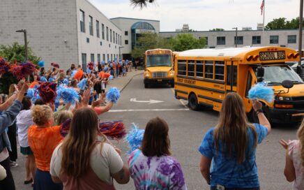 school staff waving to buses
